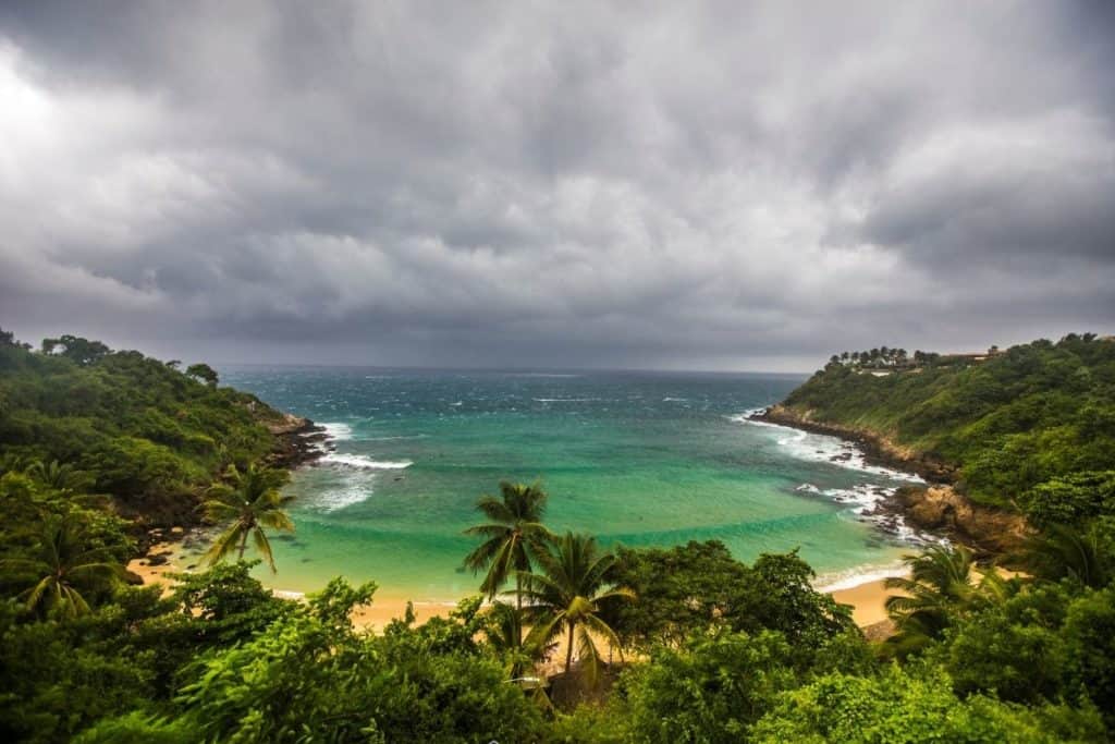 Carizarillo beach in oaxaca - an enclosed bay with green water surrounded by a tropical vegetation 