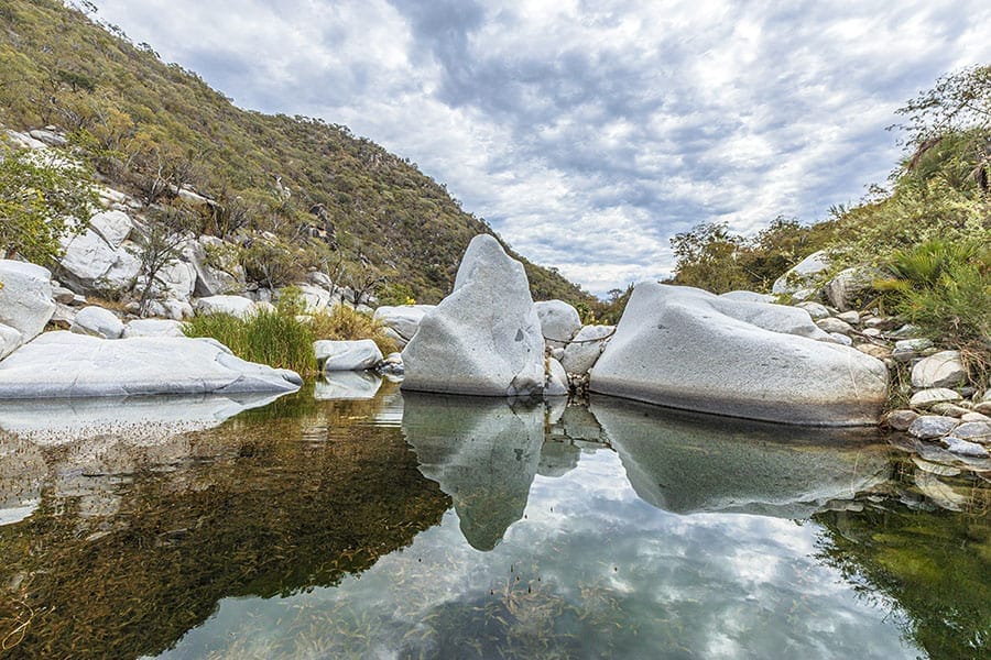 Boulders reflecting on a lake- cloud sky - Baja California road trip