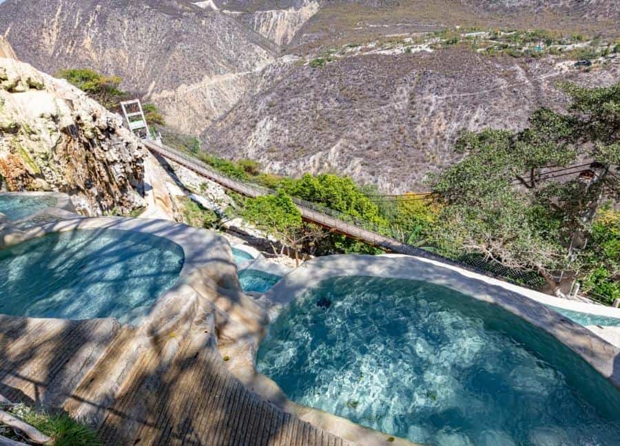VIEW FROM THE POOLS TO THE CANYON AND A SWINGING BRIDGE