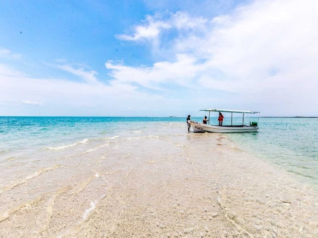 boat in the middle of a lagood on a thongue of sand