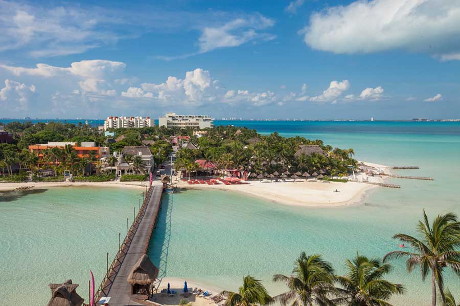 a bridge over turquoise water - things to do in Isla Mujeres