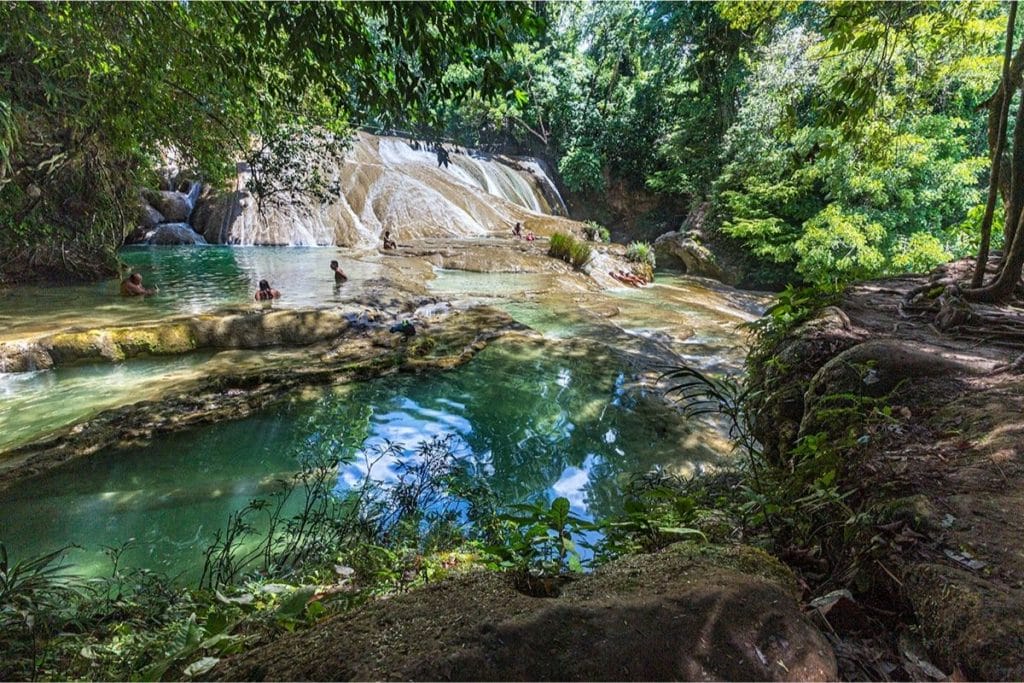 people bathing in the waterfalls and natural pools