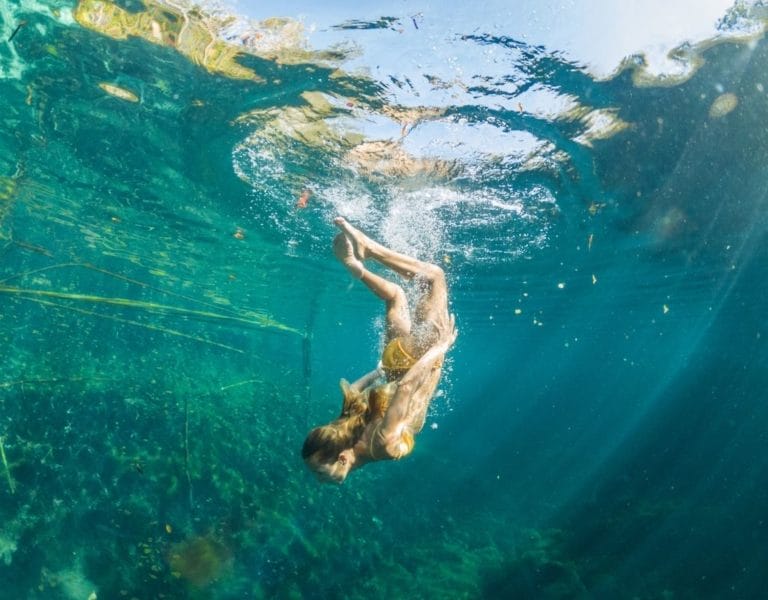 girl swimming in a cenote
