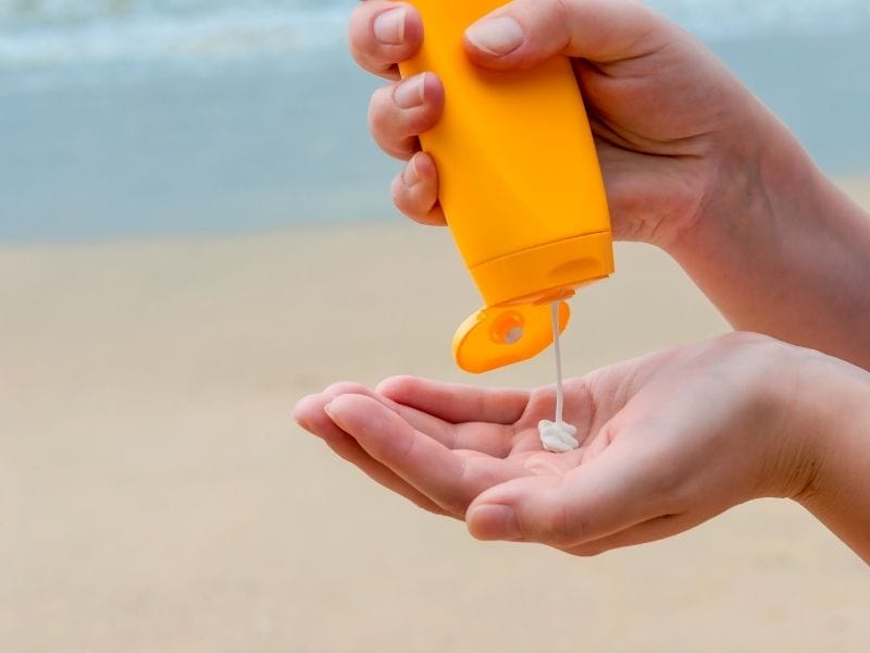 woman pouring sunscreen on her hand