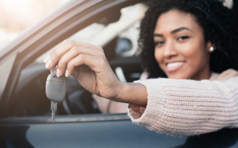Girl inside a car with a key, renting a car in Playa del Carmen