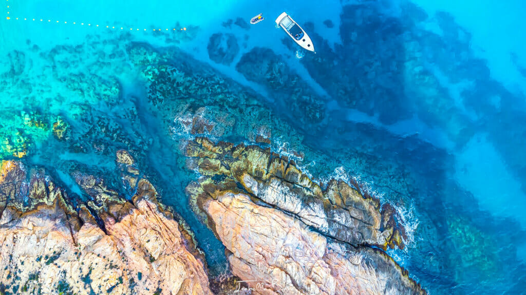 Aerial view of Playa Santa Maria and a white boat and a man swimming