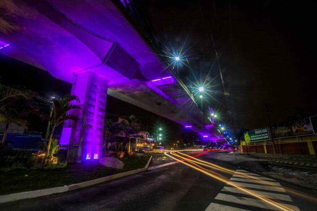 View of a road in Veracruz during night with flashing neon lights.