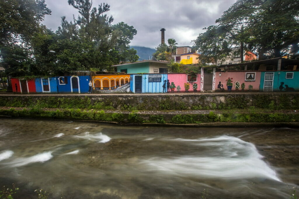View of a strong current river under a cloudy day in Orizaba Veracruz surrounded by colorful walls.