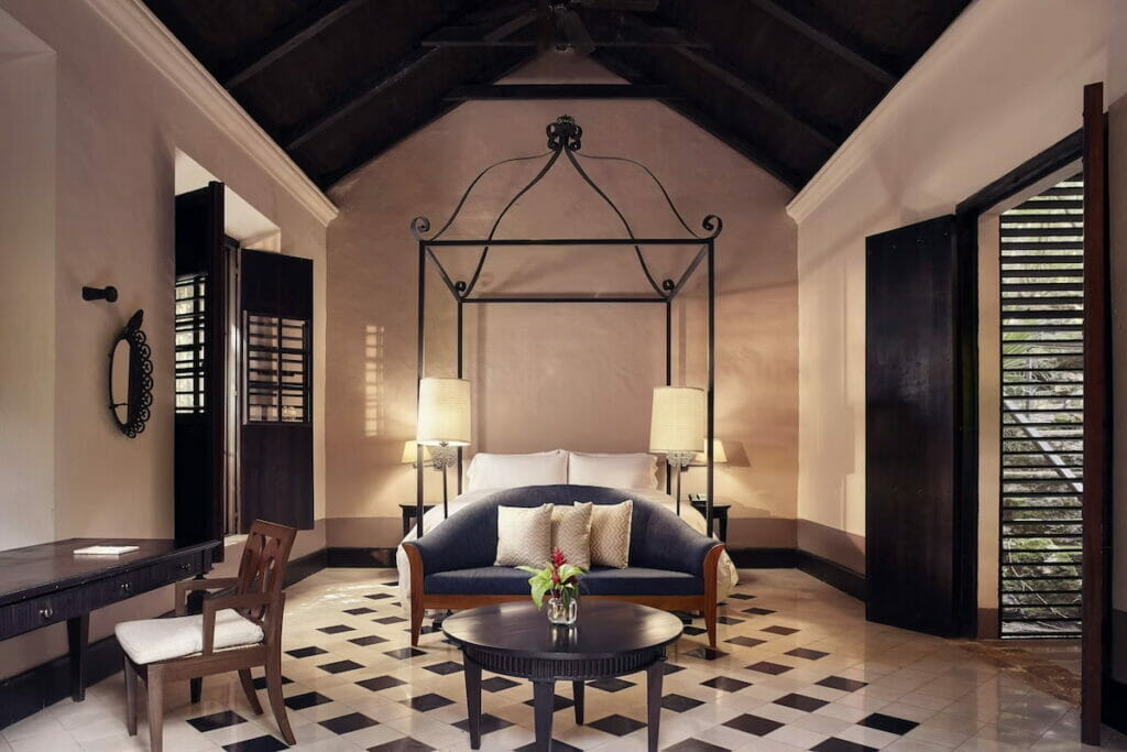 A black and white room with a bed and a couch below it.