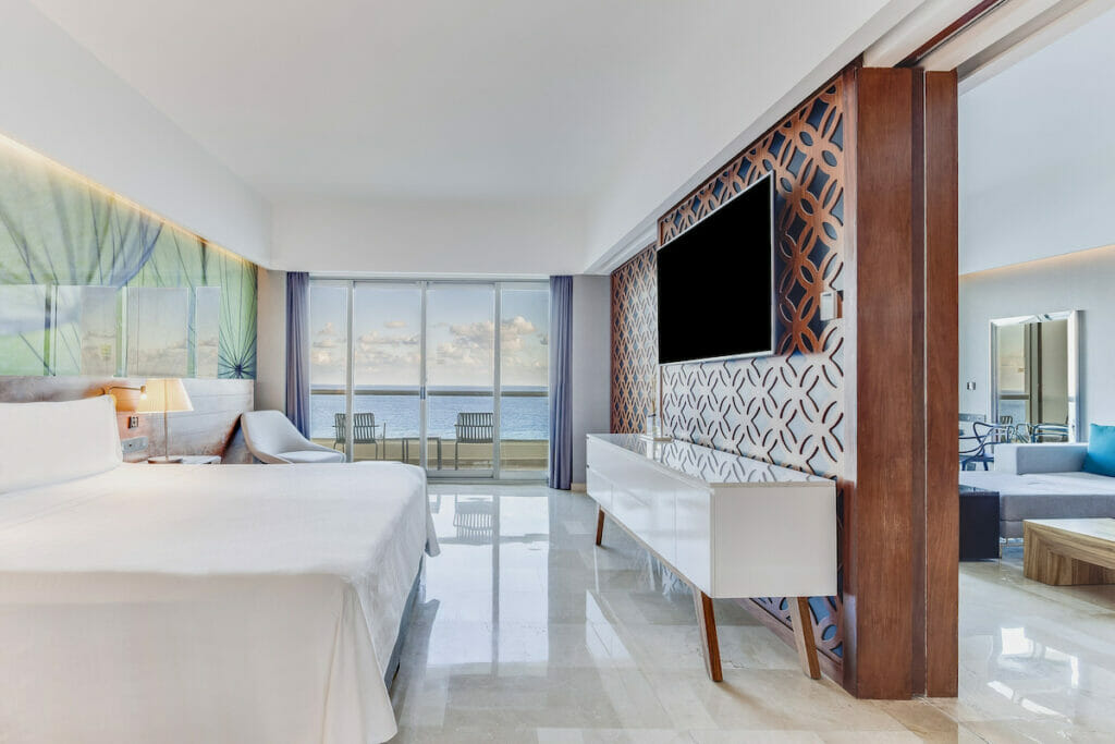 Large room with a beach view in Live Aqua Beach Resort in Cancun with a living room on the other side.