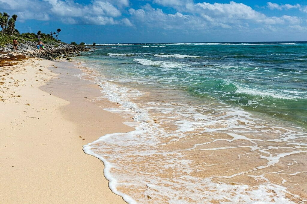The shore of Xcacel Beach with small waves.