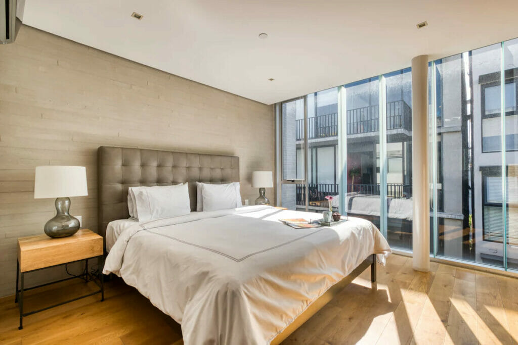A spacious room with a king size bed and a ceiling-to-floor windows.