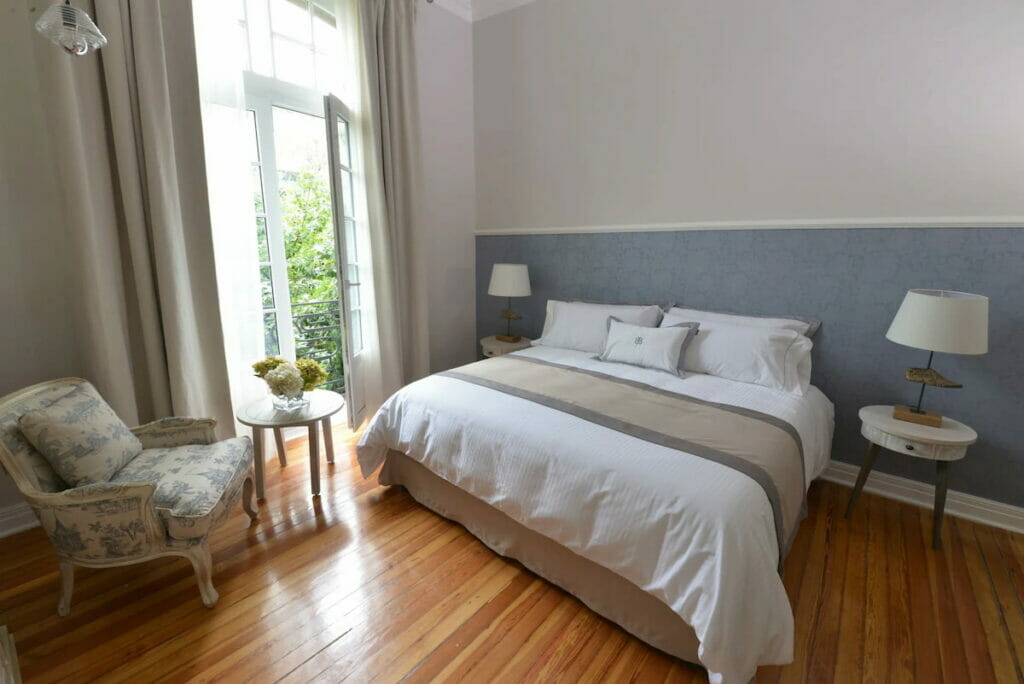 A room with wooden floor design and  cozy bed.
