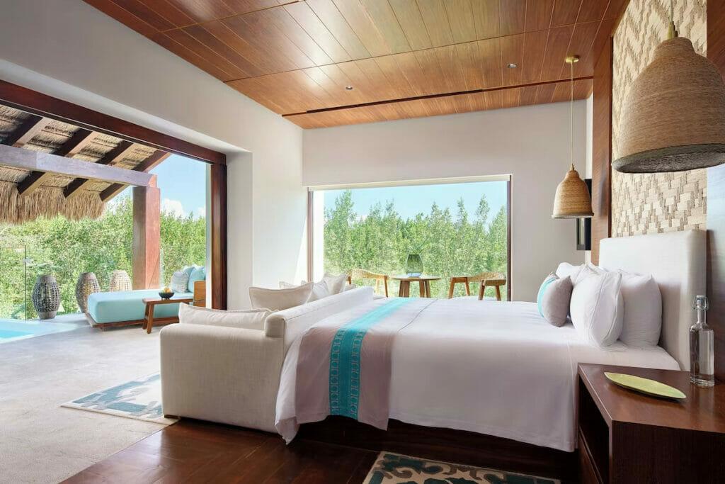 A hotel room with a cozy bed near the private pool.