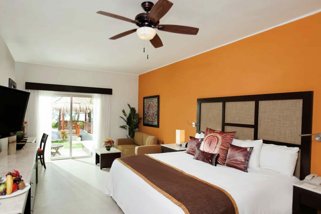 One of the best hotels in Maroma with a cozy bed, tables and chairs and a balcony.