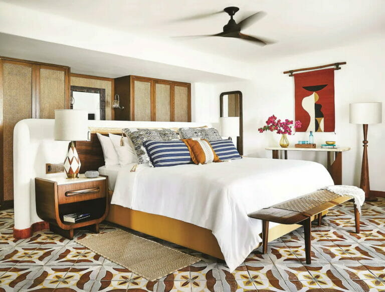 A hotel in Punta Maroma that offers a cozy bed, tables and chairs.