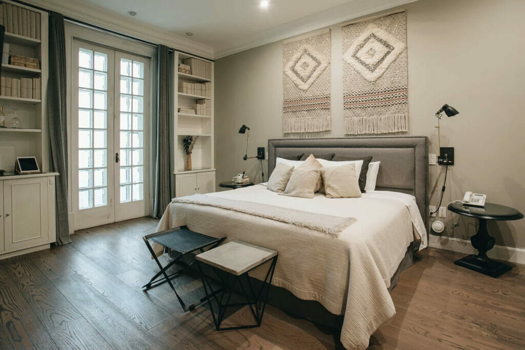 A luxury hotel with a comfy bed and a small bench.