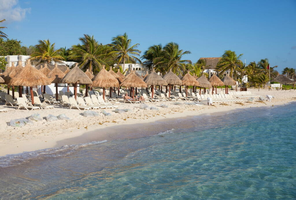 View of the oceanfront in Tulum filled with huts.
