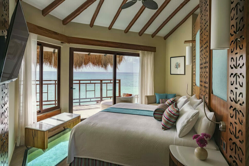 An overwater bungalow room with an ocean view from the balcony.