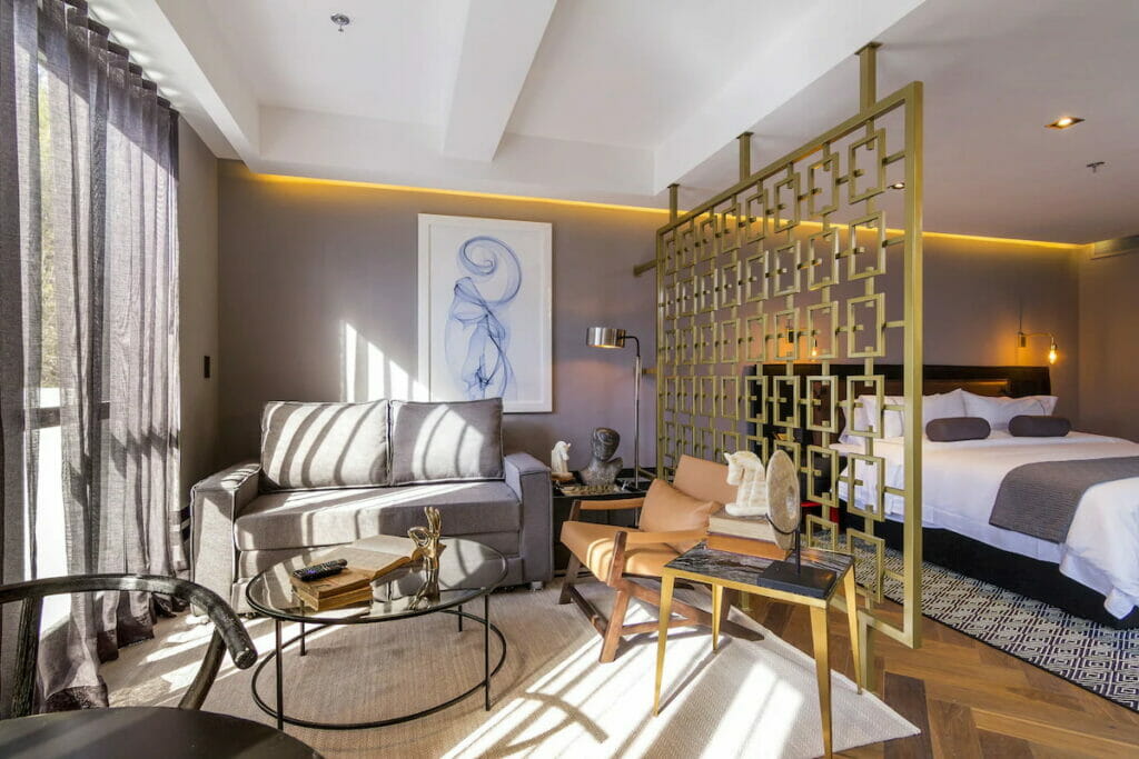 View of a bedroom and living room divided by a wall accent.