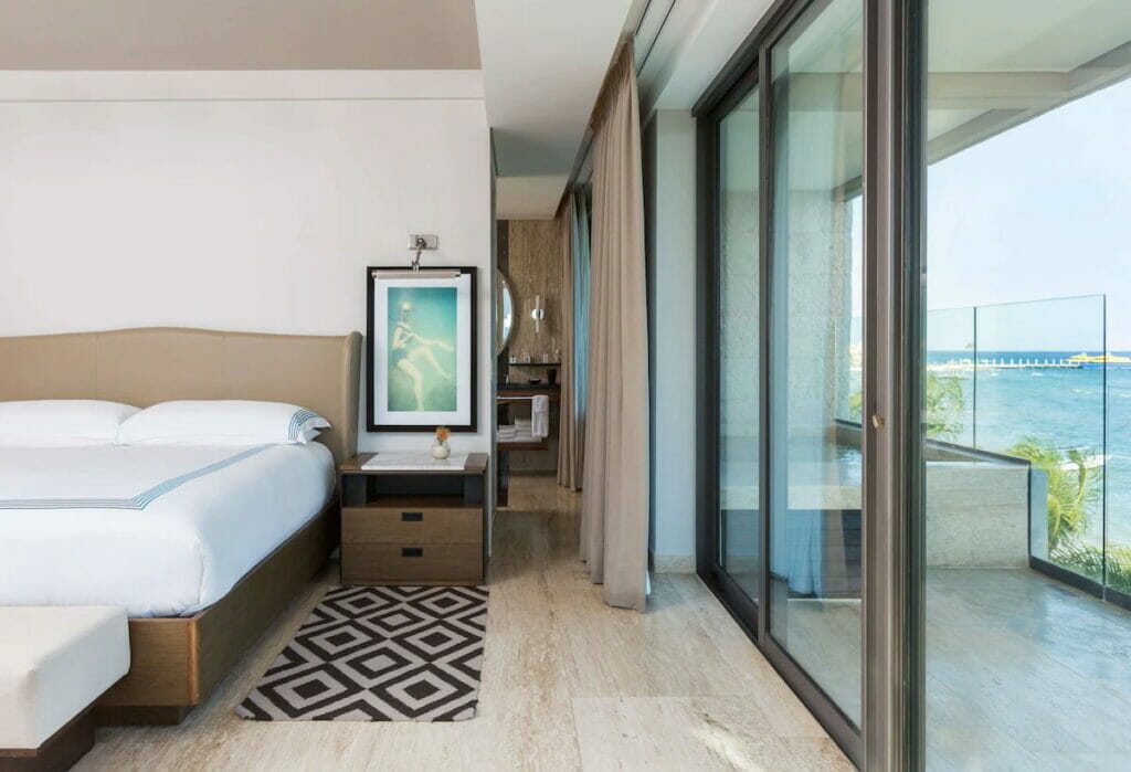 View of the luxury hotel in Playa del Carmen with a cozy bed and a balcony with an amazing view of the beach.
