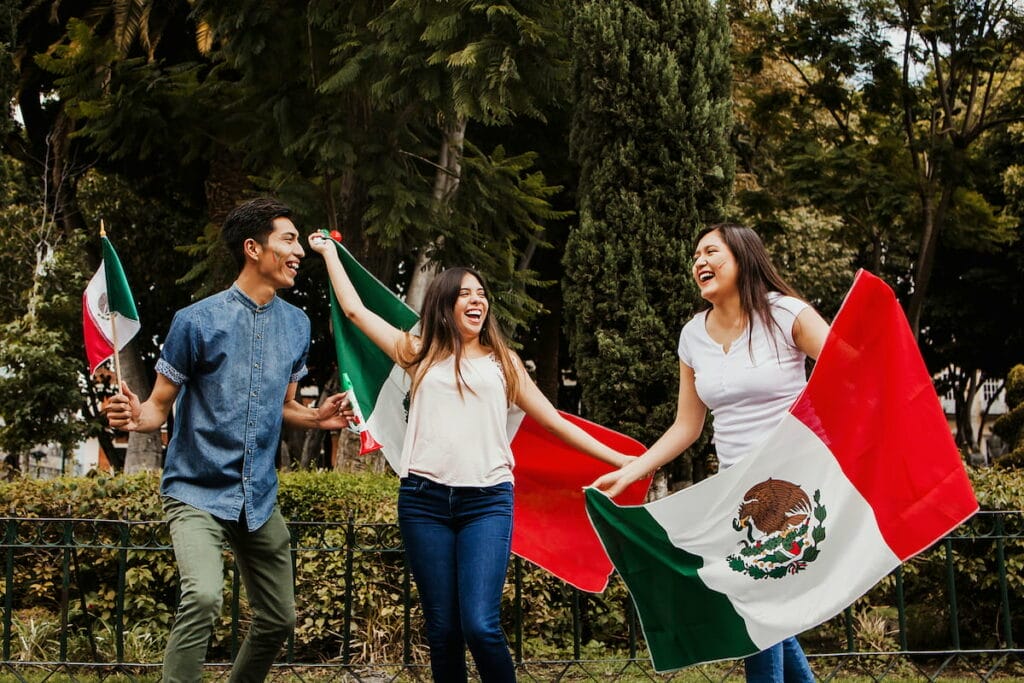 A group of friends holding up the Mexican flag.