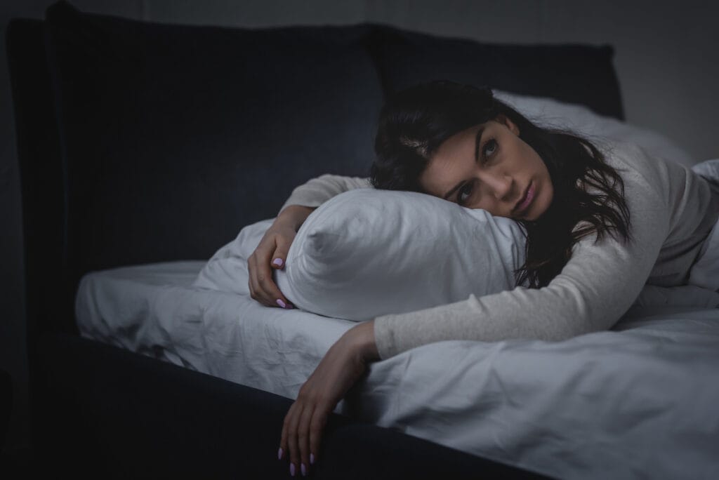 Woman lying down in bed.
