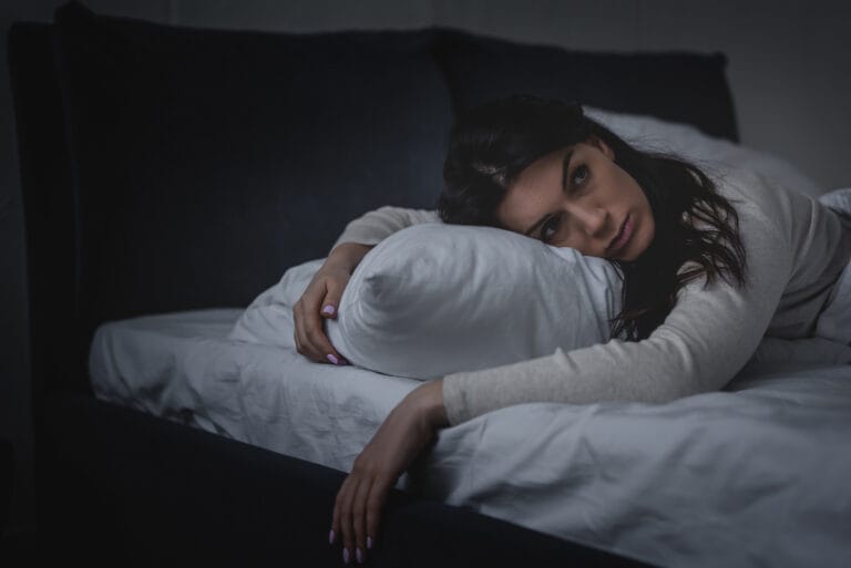 Woman lying down in bed.