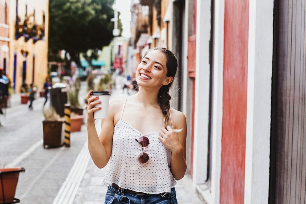 A woman walking happily on a street in Mexico CIty.