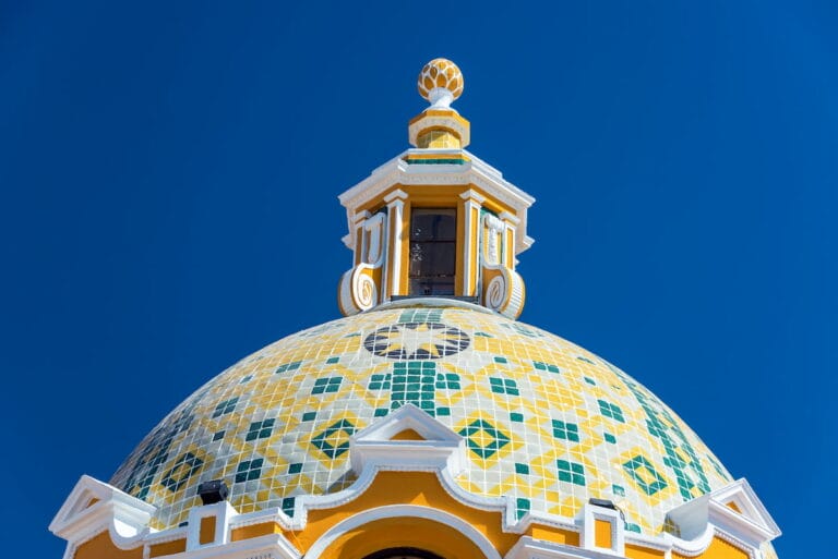 The Church of Our Lady of Remedies dome under a clear blue sky.