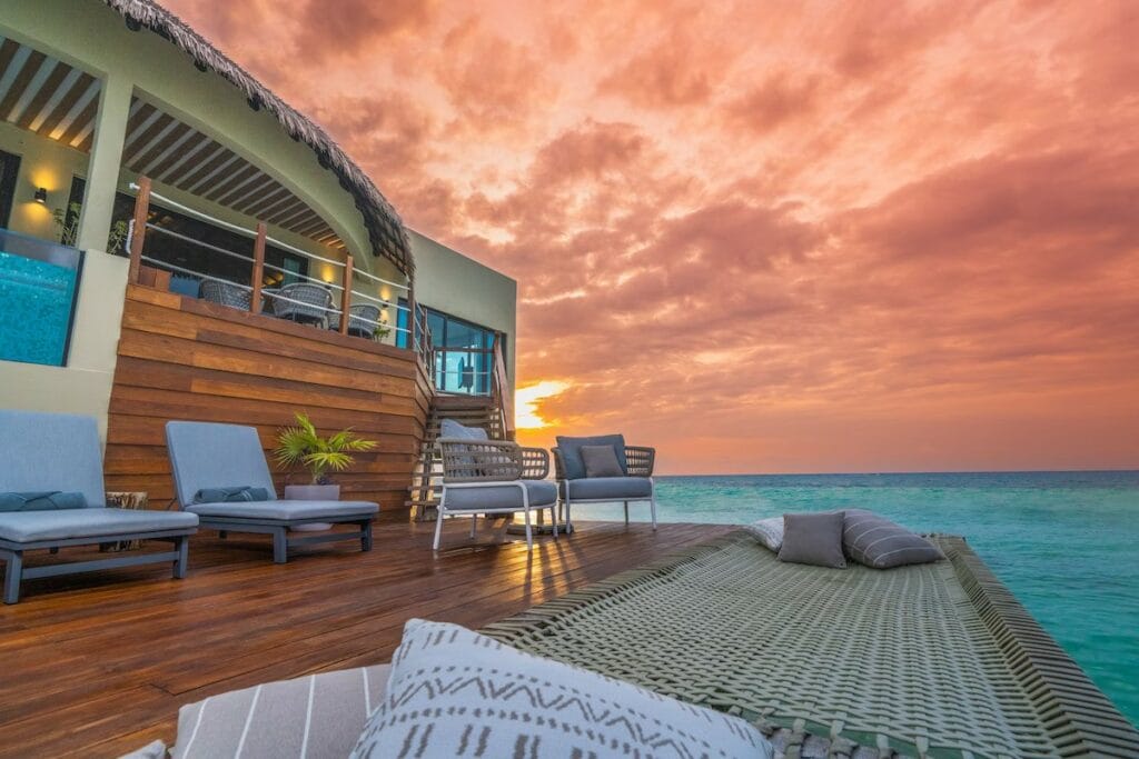 Palafitos hotel Maroma Mexico Overwater Bungalows with pink sky at sunrise