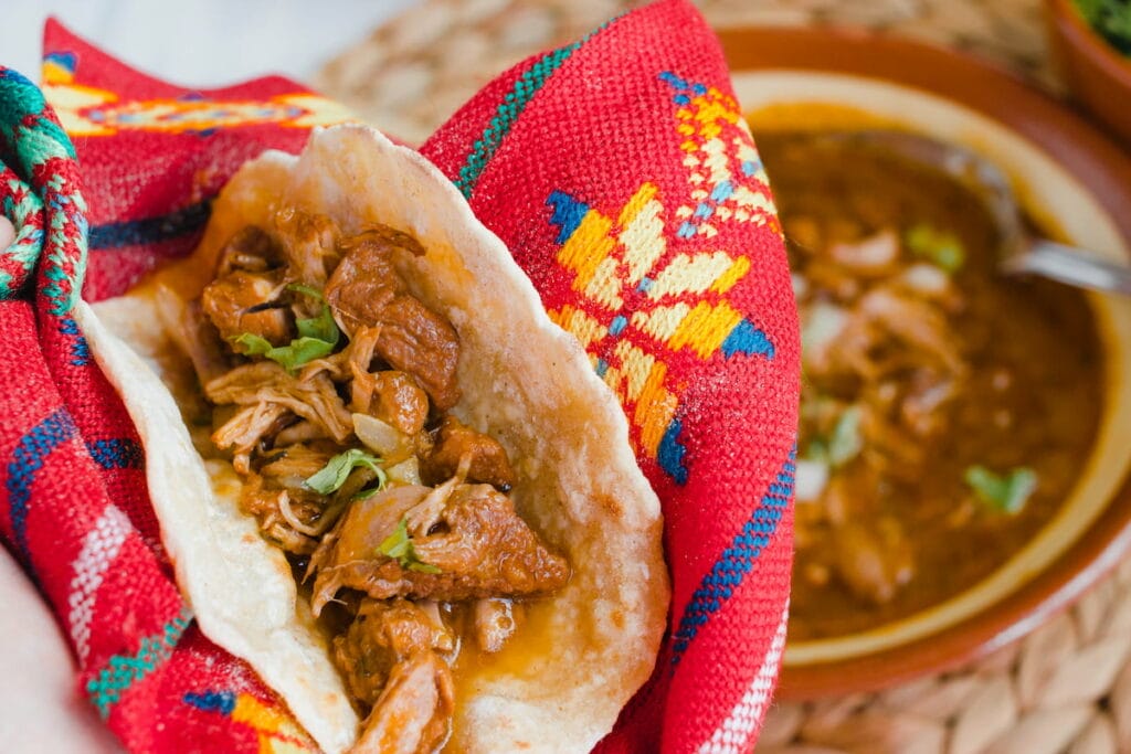 Taco de Birria wrapped in red cloth.