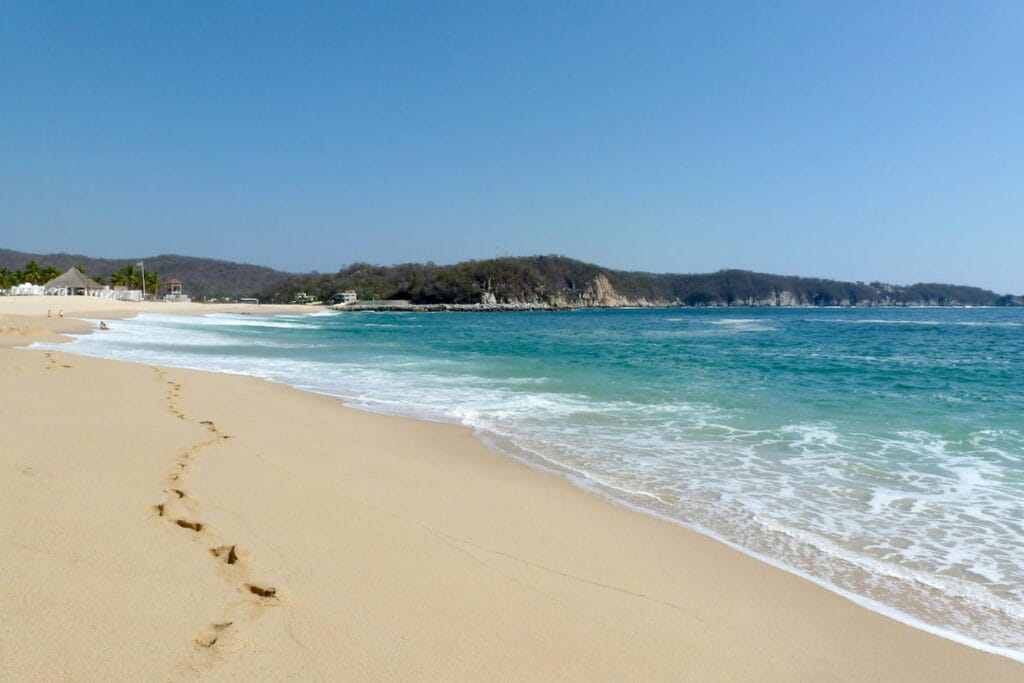 Huatulco Beach with white sand and turquoise waters.