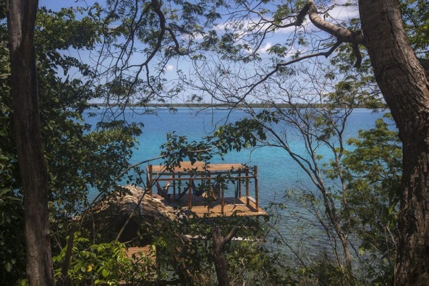 Blue lake surrounded by tree a platform with hammocks in the missle