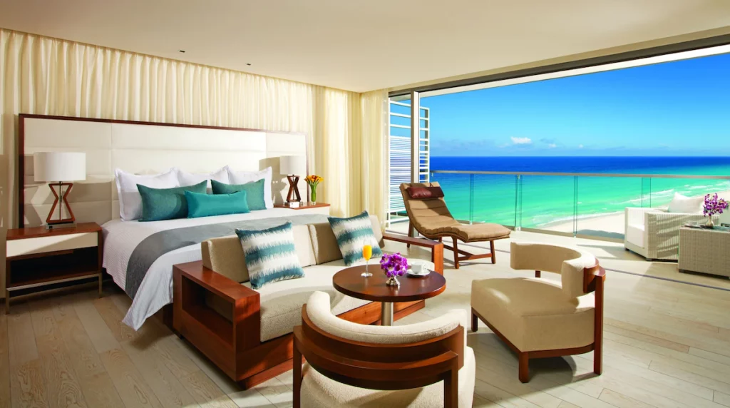 A sophisticated room in Secrets with a view of the beach from the terrace