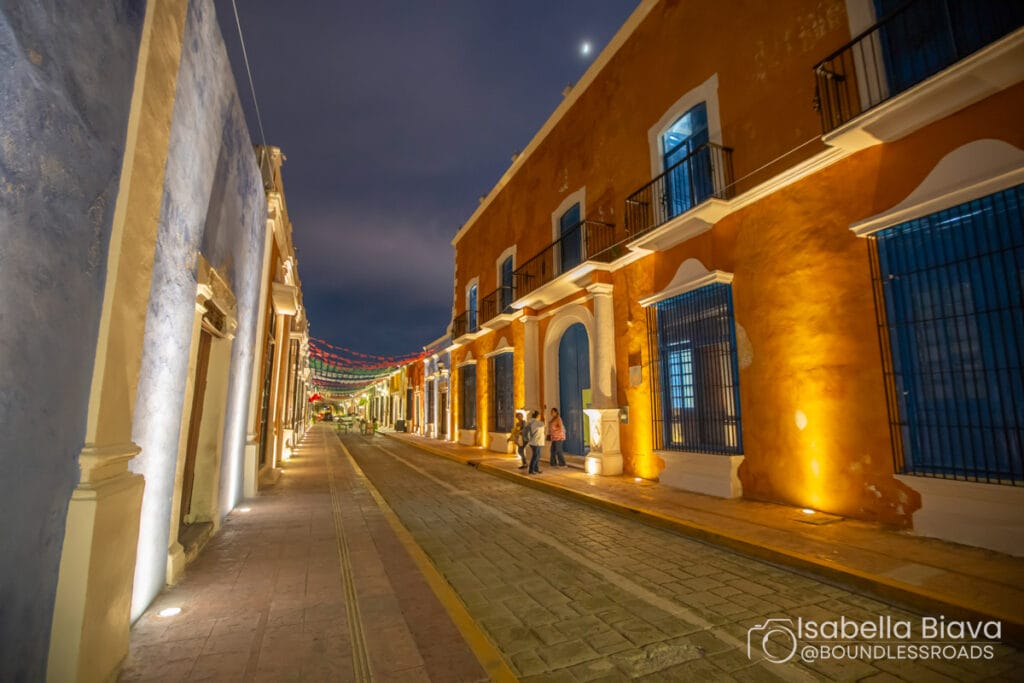 Colorful street with lit buildings at night.