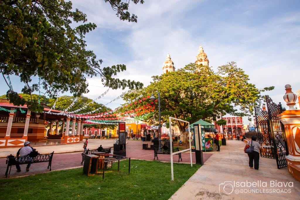 Vibrant square with colorful banners and trees.