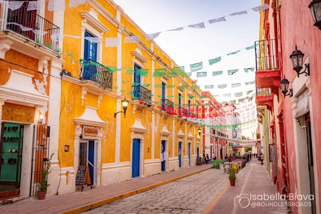 Colorful street with banners and historic buildings.