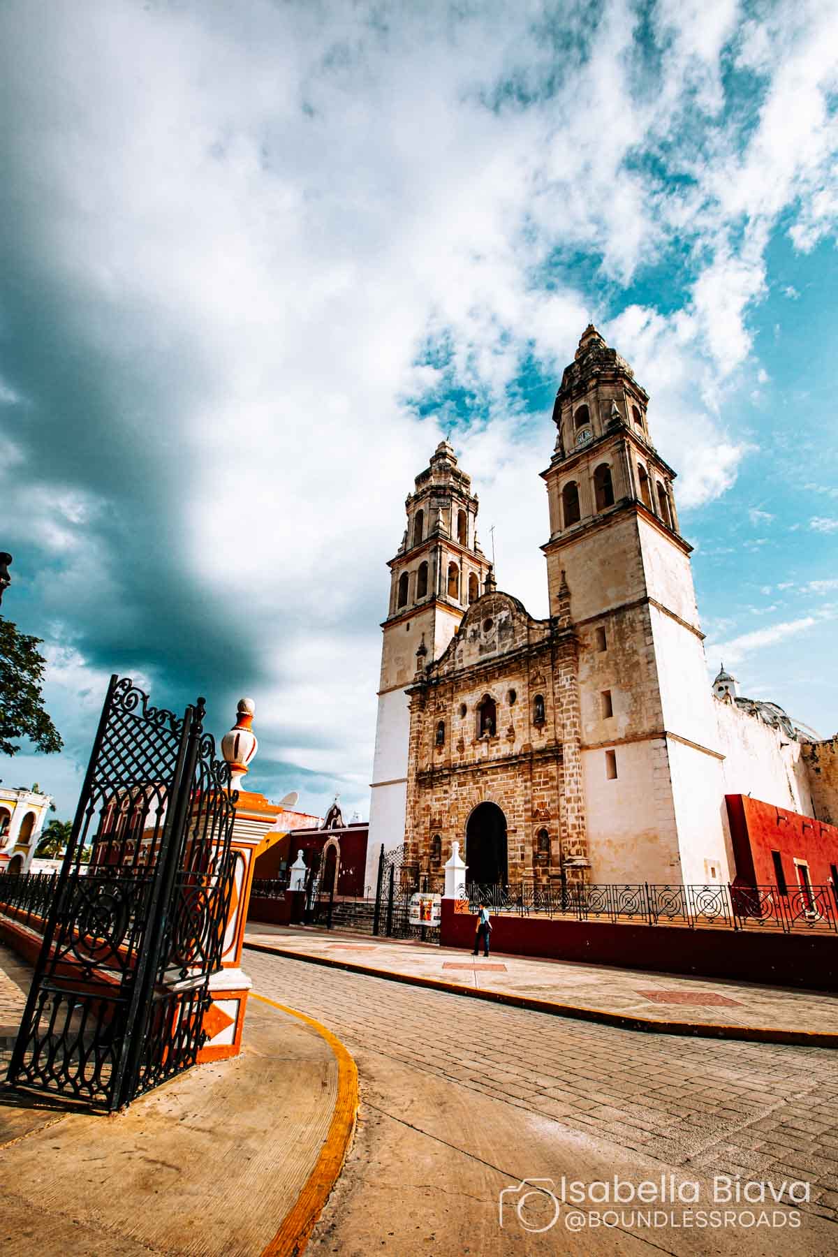 Historic cathedral with cloudy sky and street view.