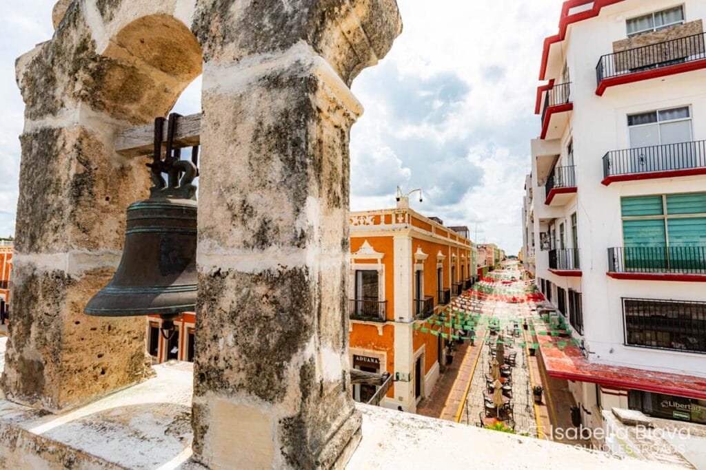 Historic city street view with bell tower and flags