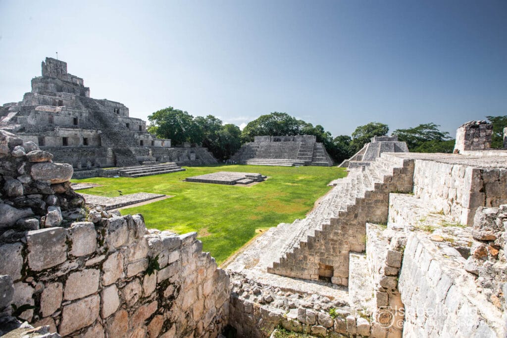 Ancient Mayan ruins with pyramid and grassy courtyard