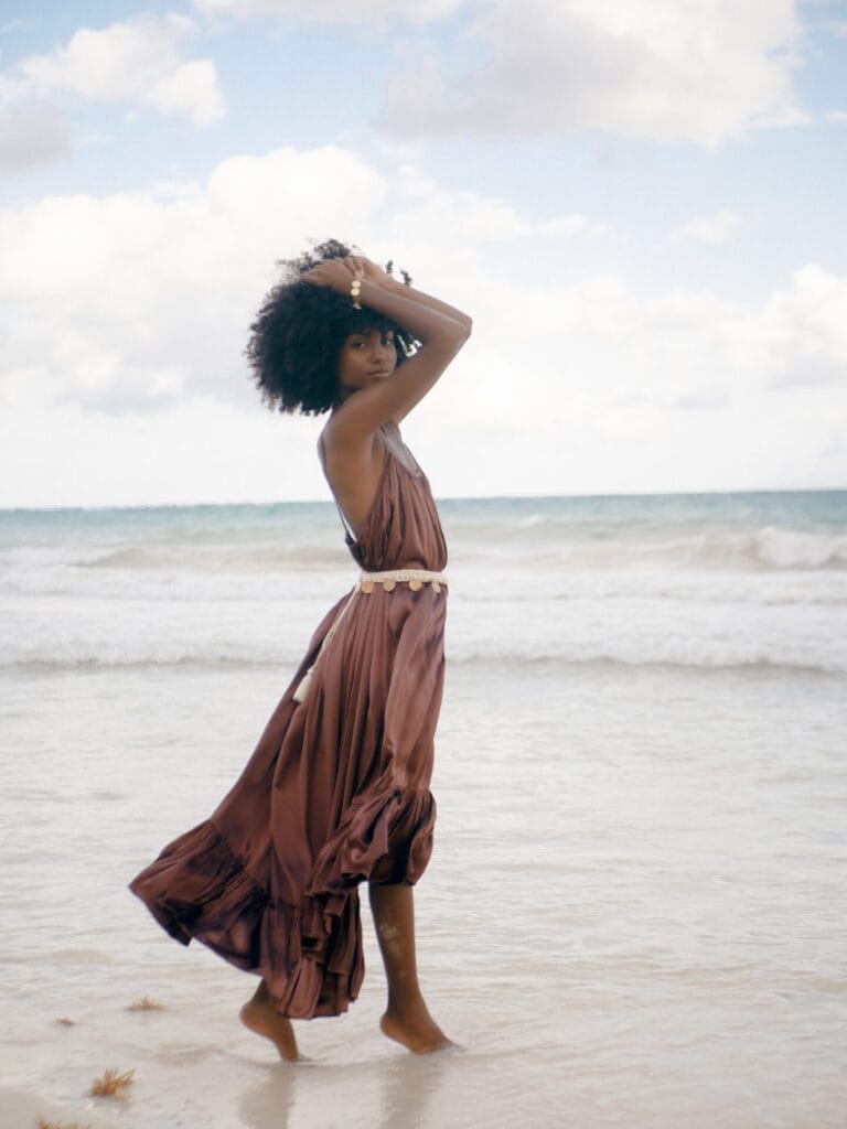 Woman in flowing dress walking on beach