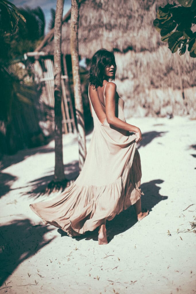 Woman in flowing dress on tropical beach